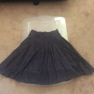 Mid length eggplant color skirt. Thin belt loop around the waist.